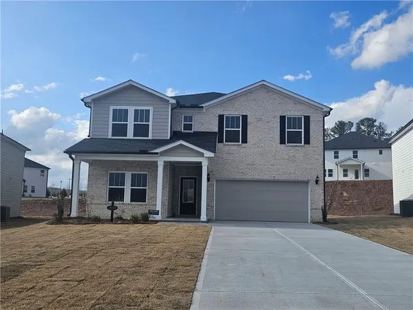 a front view of a house with a yard and garage