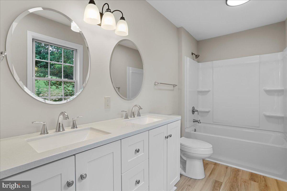 72 Pioneer Lane Berkeley Springs, WV 25411 - Photo 16 of 35 a bathroom with a toilet a sink a mirror and vanity
