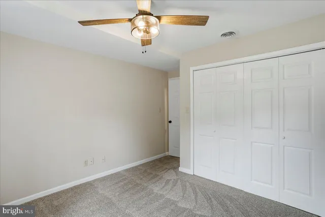 an empty room with a chandelier fan