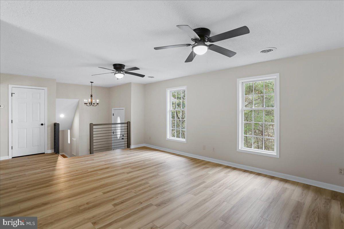72 Pioneer Lane Berkeley Springs, WV 25411 - Photo 10 of 35 a view of empty room with wooden floor and ceiling fan