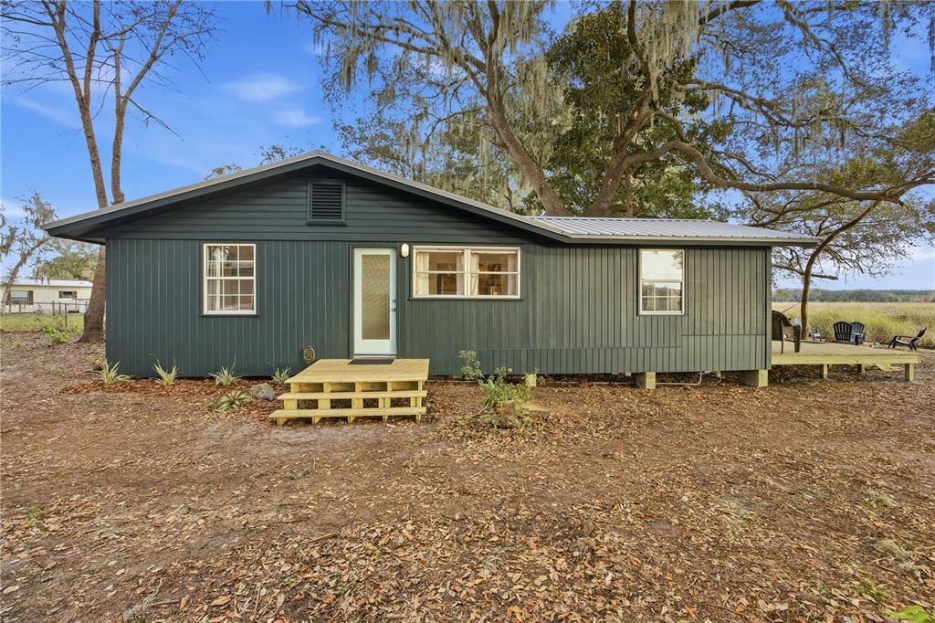 23422 Northeast 154th Place Road Salt Springs, FL 32134 - Photo 27 of 29 a backyard of a house with table and chairs