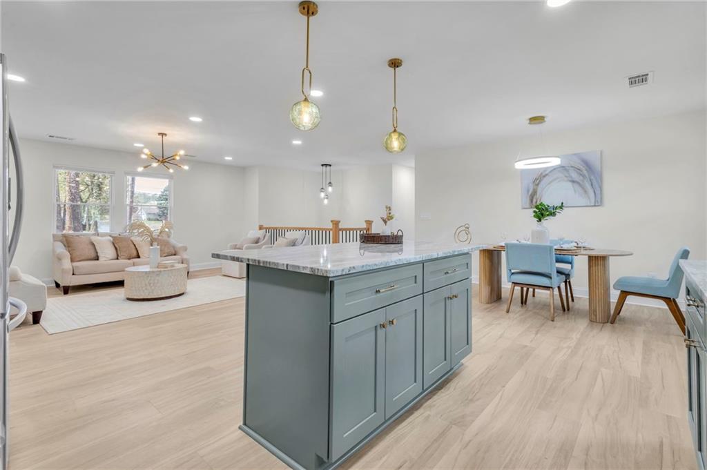 6788 Collier Way Riverdale, GA 30296 - Photo 5 of 37 a large room with kitchen island a chandelier and a view of living room
