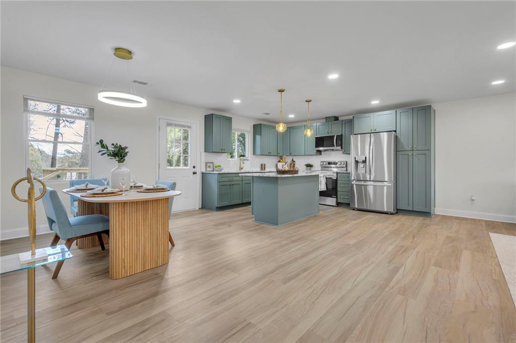 6788 Collier Way Riverdale, GA 30296 - Photo 6 of 37 a kitchen with stainless steel appliances kitchen island granite countertop a sink and cabinets