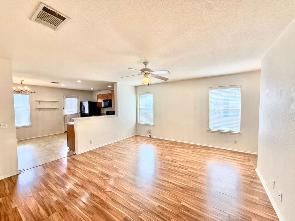 8501 Shallot Way Austin, TX 78748 - Photo 14 of 26 a view of a kitchen with wooden floor and a ceiling fan