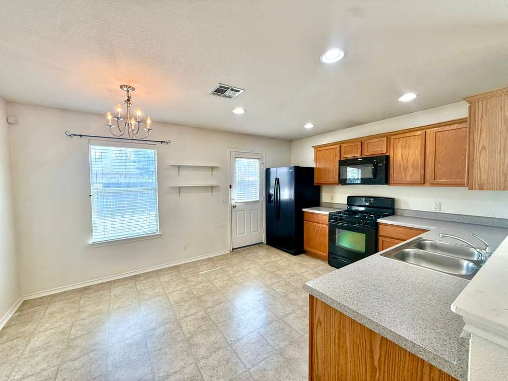 8501 Shallot Way Austin, TX 78748 - Photo 7 of 26 a kitchen with stainless steel appliances granite countertop a sink refrigerator and microwave