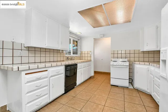 a kitchen with white cabinets and white appliances