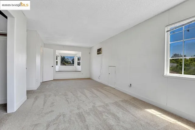 a view of a big room with windows and refrigerator