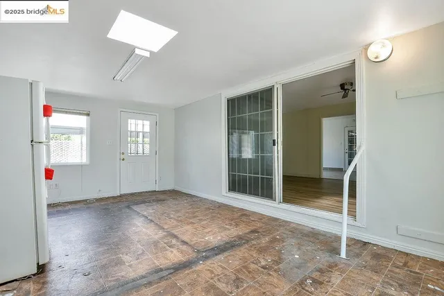 an empty room with windows and cabinet