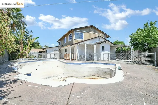 a view of house with swimming pool and sitting area