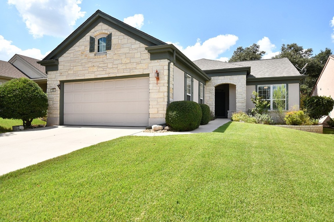 a front view of a house with a yard and garage