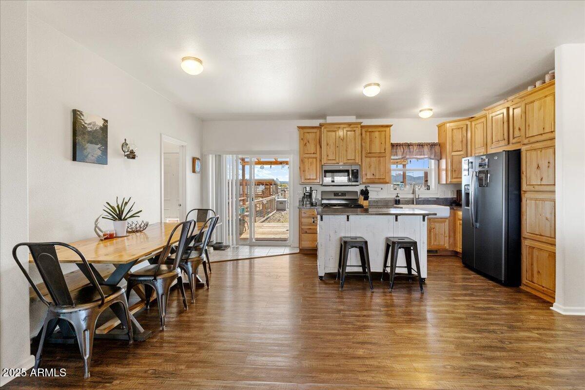 3107 West Country Quail Trail Paulden, AZ 86334 - Photo 11 of 46 a kitchen with stainless steel appliances a dining table chairs and refrigerator