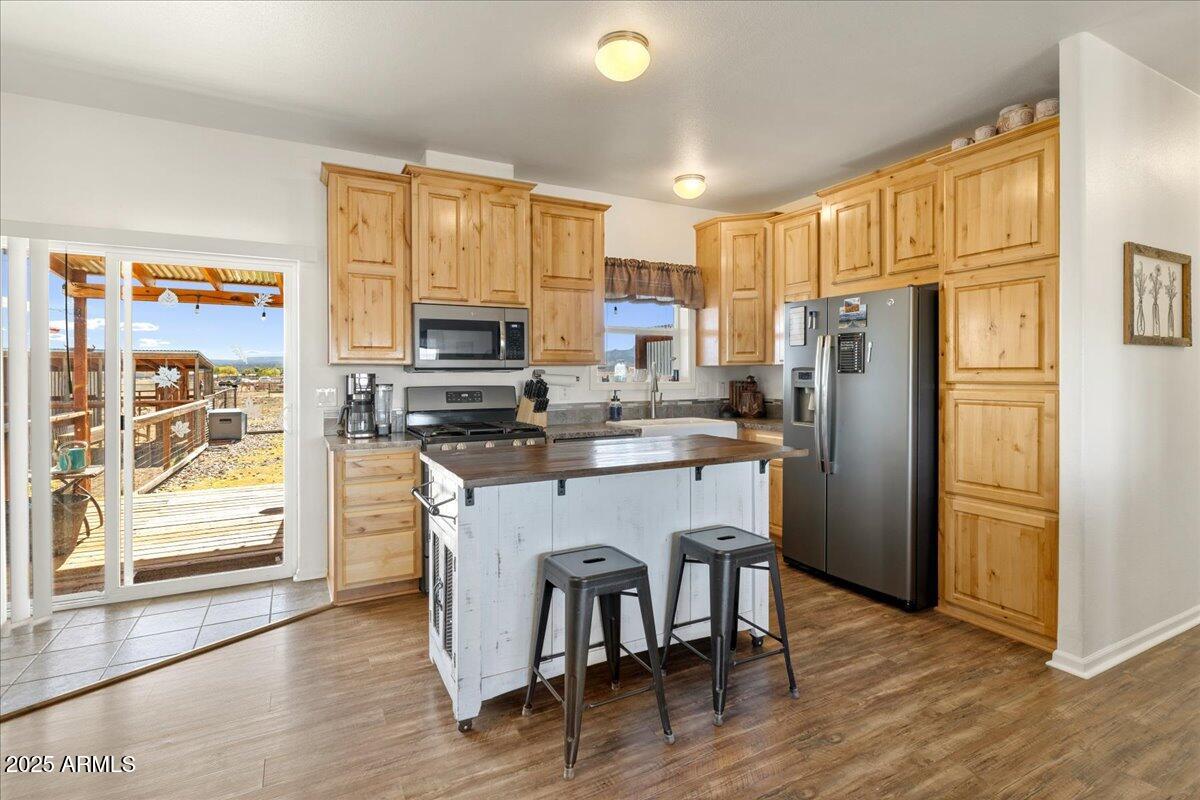 3107 West Country Quail Trail Paulden, AZ 86334 - Photo 12 of 46 a kitchen with stainless steel appliances granite countertop a refrigerator a stove top oven a sink and a dining table with wooden floor