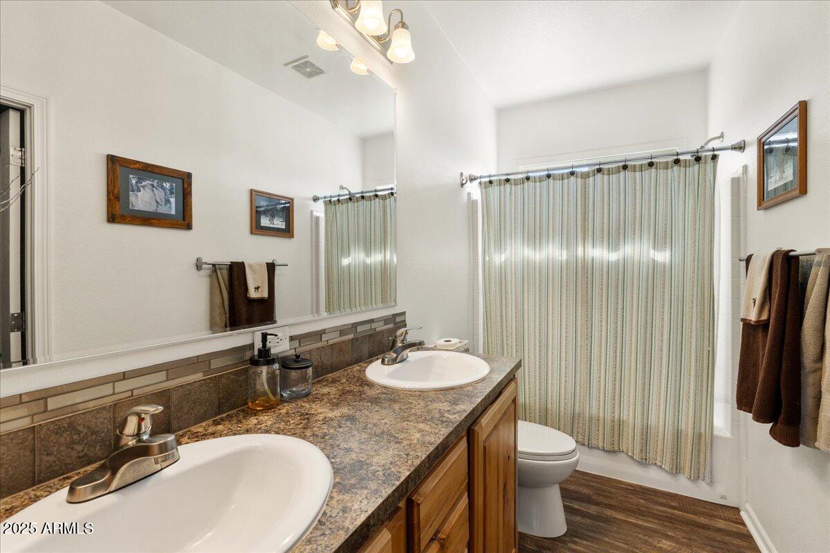 3107 West Country Quail Trail Paulden, AZ 86334 - Photo 17 of 47 a bathroom with a granite countertop sink a toilet a mirror and shower