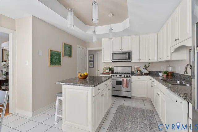 a kitchen with granite countertop white cabinets and white appliances