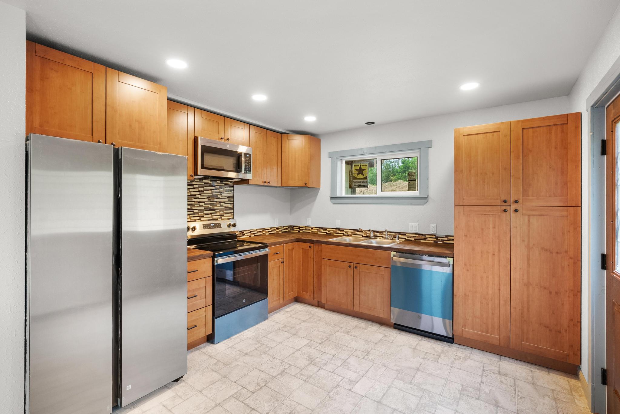 89-811 Huanui Road Captain Cook, HI 96704 - Photo 18 of 30 a kitchen with stainless steel appliances granite countertop a refrigerator and a stove top oven
