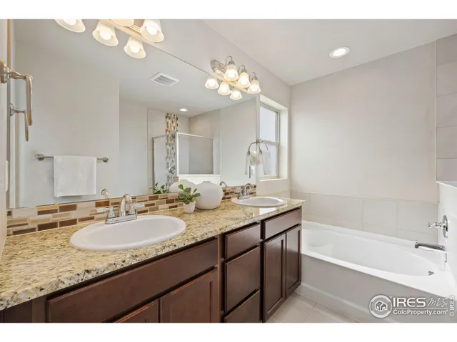 a bathroom with a granite countertop sink a large mirror and a bathtub