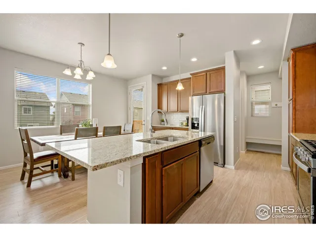 a kitchen with stainless steel appliances granite countertop a sink a stove and a refrigerator