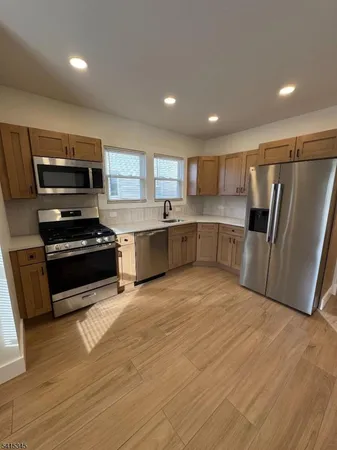 a kitchen with stainless steel appliances granite countertop a refrigerator and a stove top oven
