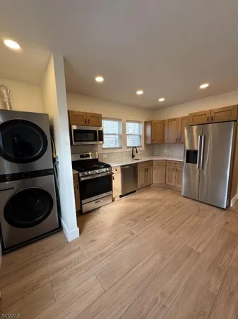 a kitchen with stainless steel appliances granite countertop a refrigerator and a stove top oven
