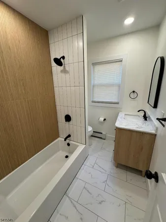 a bathroom with a tub sink and mirror