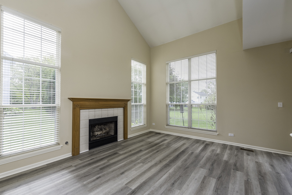 17876 Braewick Road Gurnee, IL 60031 - Photo 23 of 28 a view of empty room with wooden floor and fireplace