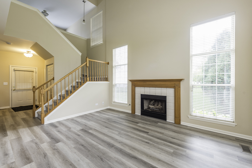 17876 Braewick Road Gurnee, IL 60031 - Photo 8 of 28 a view of an empty room with wooden floor fireplace and a window
