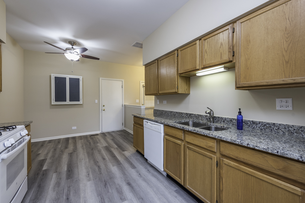 17876 Braewick Road Gurnee, IL 60031 - Photo 10 of 28 a kitchen with granite countertop a sink cabinets stainless steel appliances and a counter space