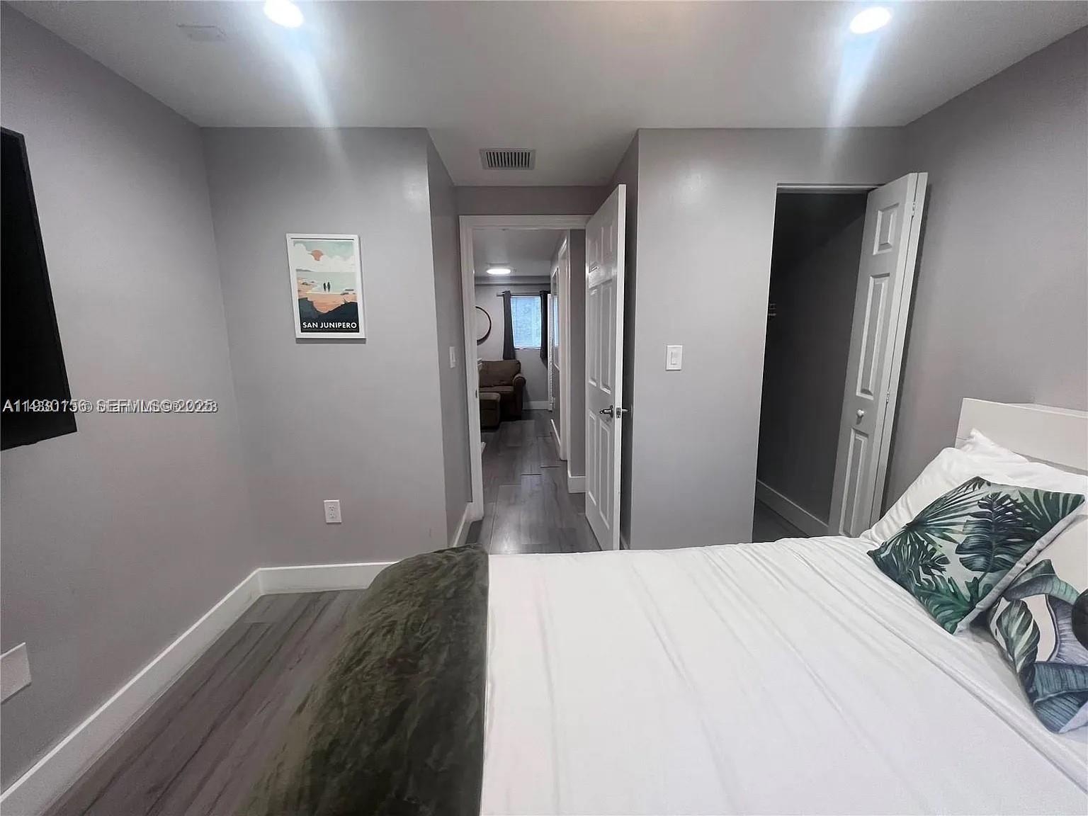 821 Southwest 2nd Street, Unit 2 Miami, FL 33130 - Photo 8 of 12 a bedroom with a bed and a mirror