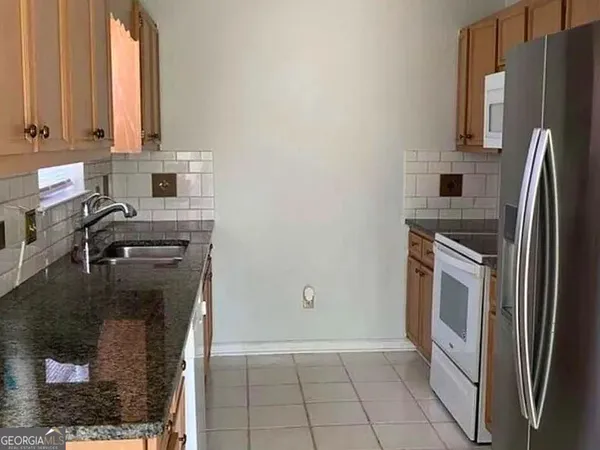 a kitchen with a refrigerator sink and cabinets