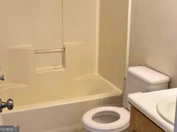 a white toilet sitting next to a bath tub