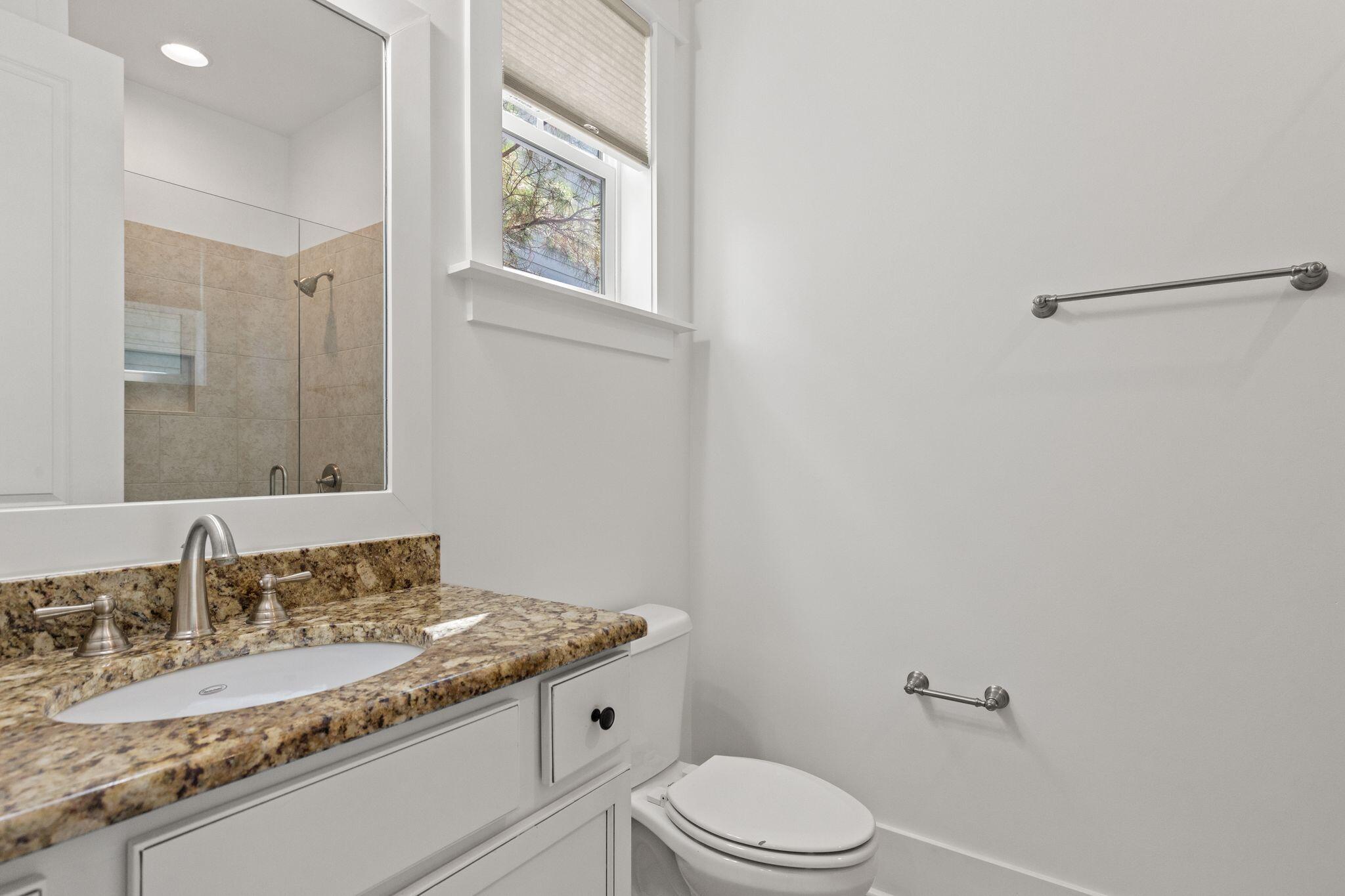 694 Flatwoods Forest Loop Santa Rosa Beach, FL 32459 - Photo 14 of 54 a bathroom with a granite countertop sink mirror vanity and toilet