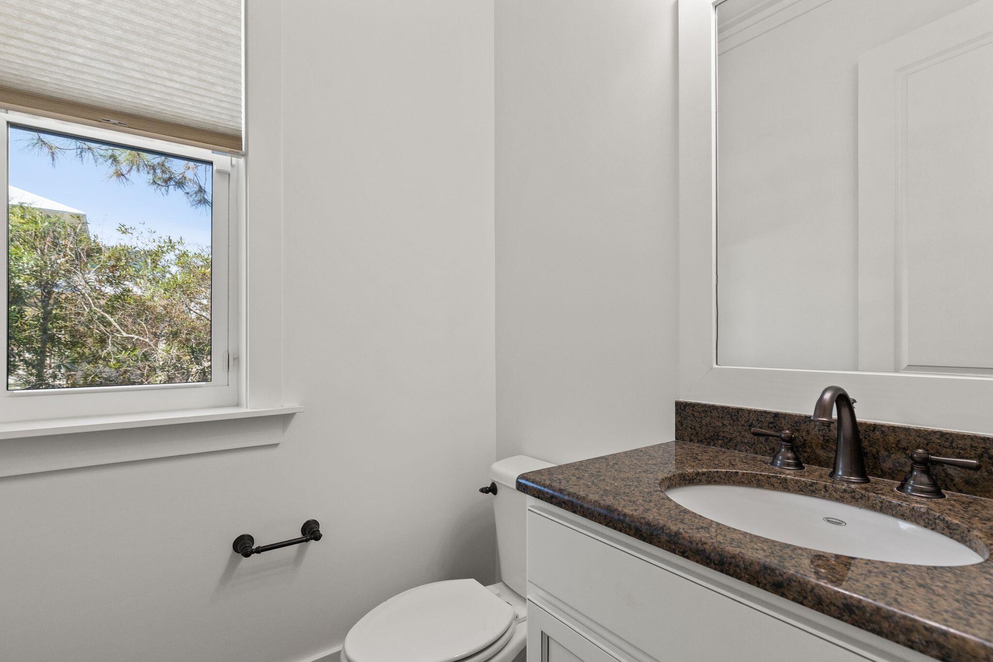 694 Flatwoods Forest Loop Santa Rosa Beach, FL 32459 - Photo 35 of 54 a bathroom with a granite countertop sink toilet and mirror