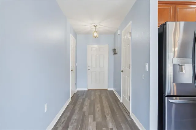a view of a hallway with wooden floor and cabinets