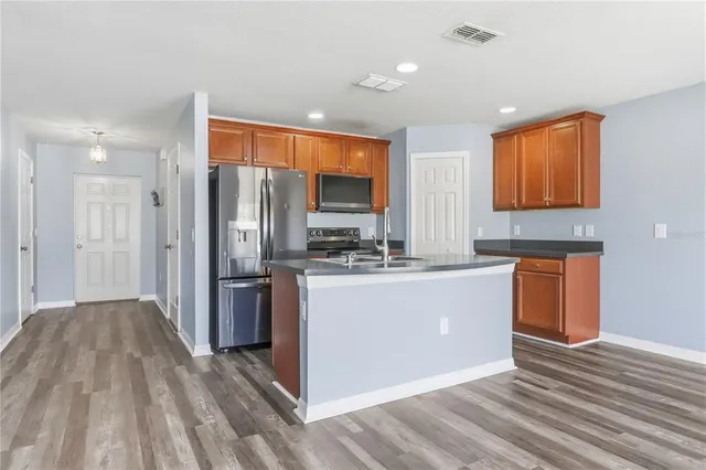 a kitchen with stainless steel appliances granite countertop a refrigerator and a stove