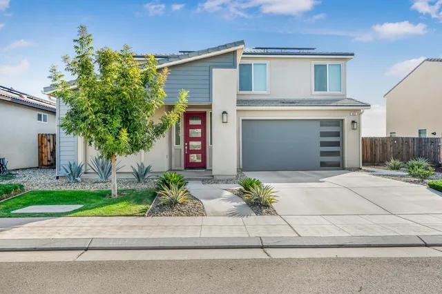 a front view of a house with a yard and a garage