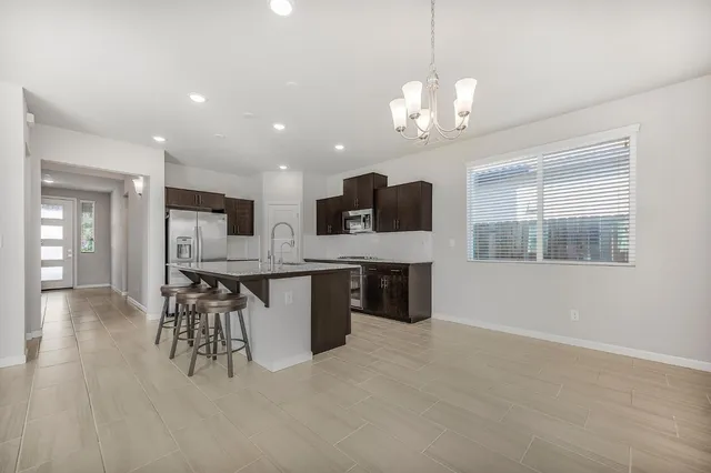a large kitchen with stainless steel appliances kitchen island granite countertop a sink and cabinets