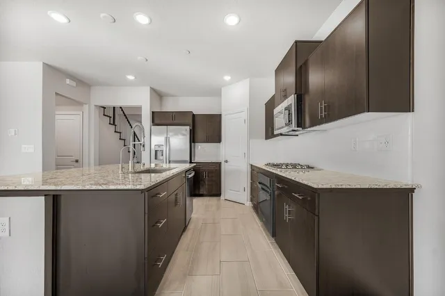 a kitchen with stainless steel appliances granite countertop a stove microwave and refrigerator