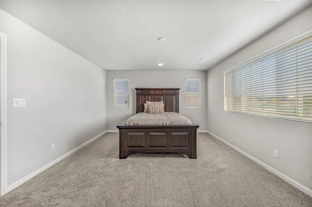 a spacious bedroom with a bed and a window
