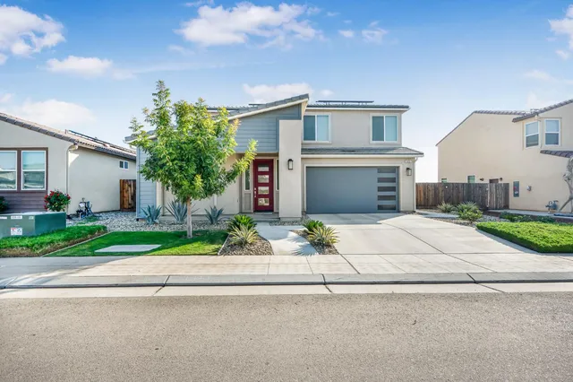 a front view of a house with a yard and a garage