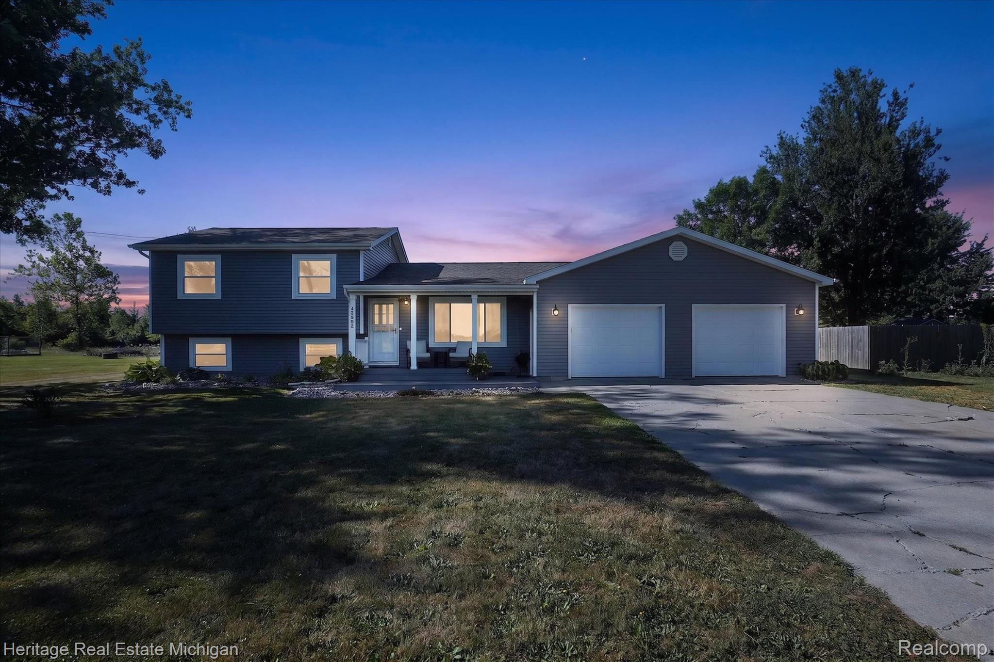 7225 Baldwin Road Swartz Creek, MI 48473 - Photo 1 of 44 Split-level home featuring grey siding, a covered front porch, and an attached two-car garage