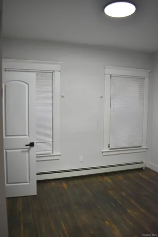 an empty room with wooden floor and white cabinet