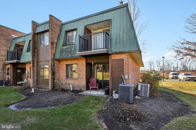 a view of a brick house with many windows next to a yard
