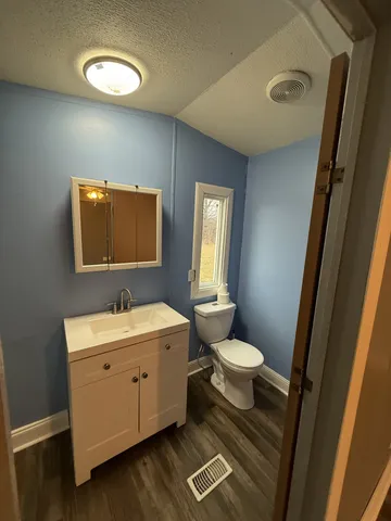 a bathroom with a toilet sink and mirror