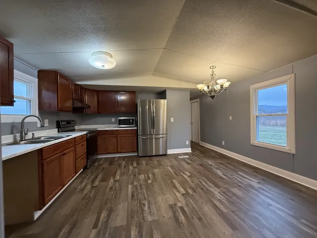 a large kitchen with cabinets wooden floor and stainless steel appliances