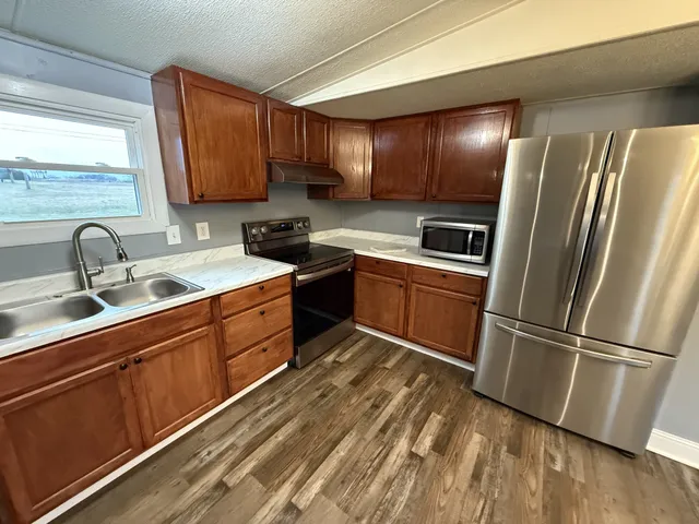 a kitchen with stainless steel appliances granite countertop a refrigerator sink and cabinets