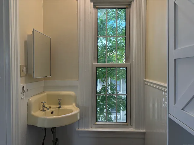 a bathroom with a sink a window and a toilet