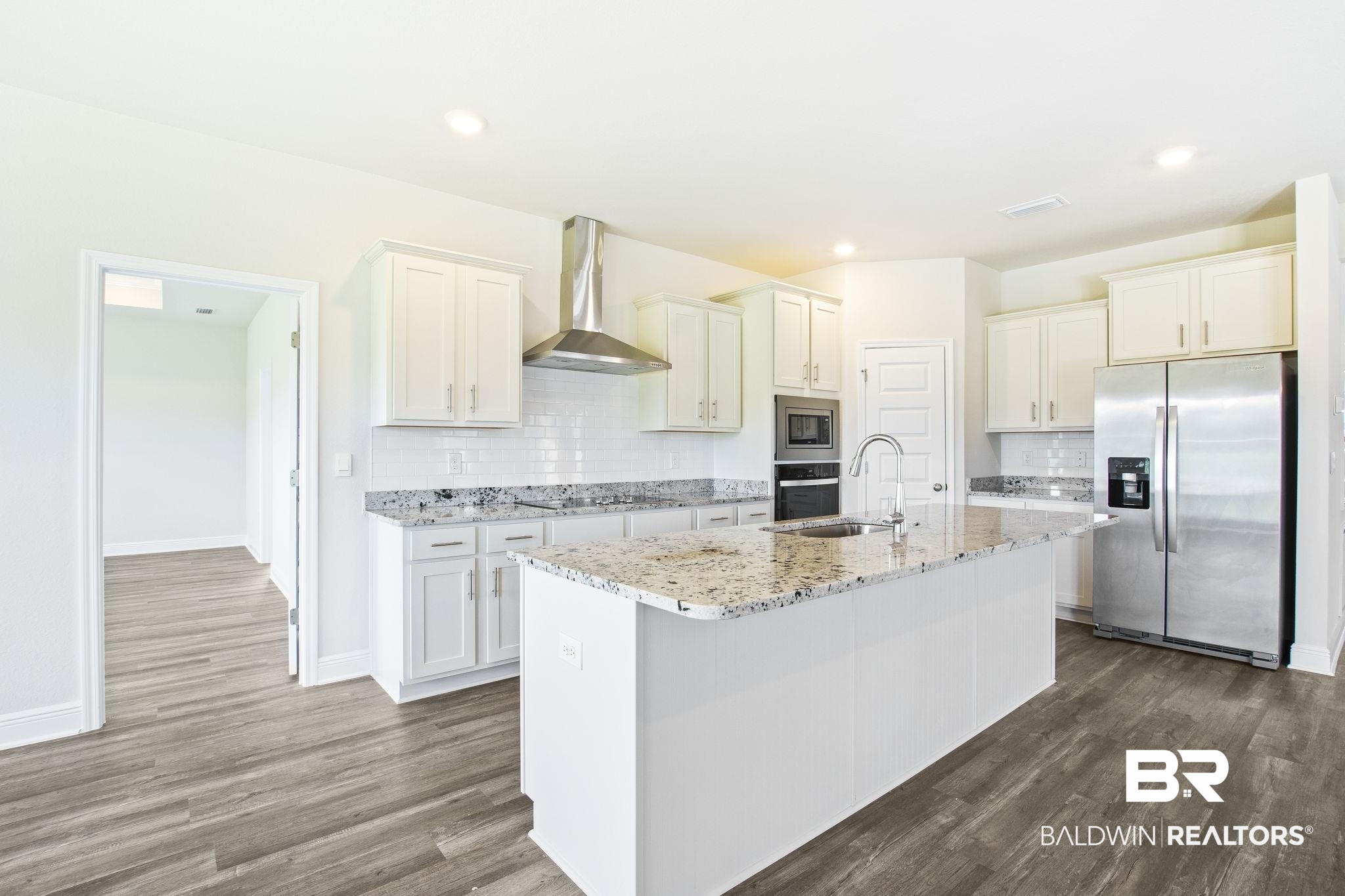 11303 Genuine Risk Circle Daphne, AL 36526 - Photo 22 of 100 Kitchen with decorative backsplash, an island with sink, stainless steel appliances, and wall chimney range hood
