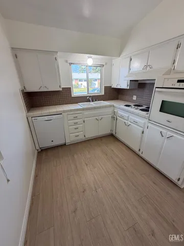 a kitchen with granite countertop white cabinets and white appliances