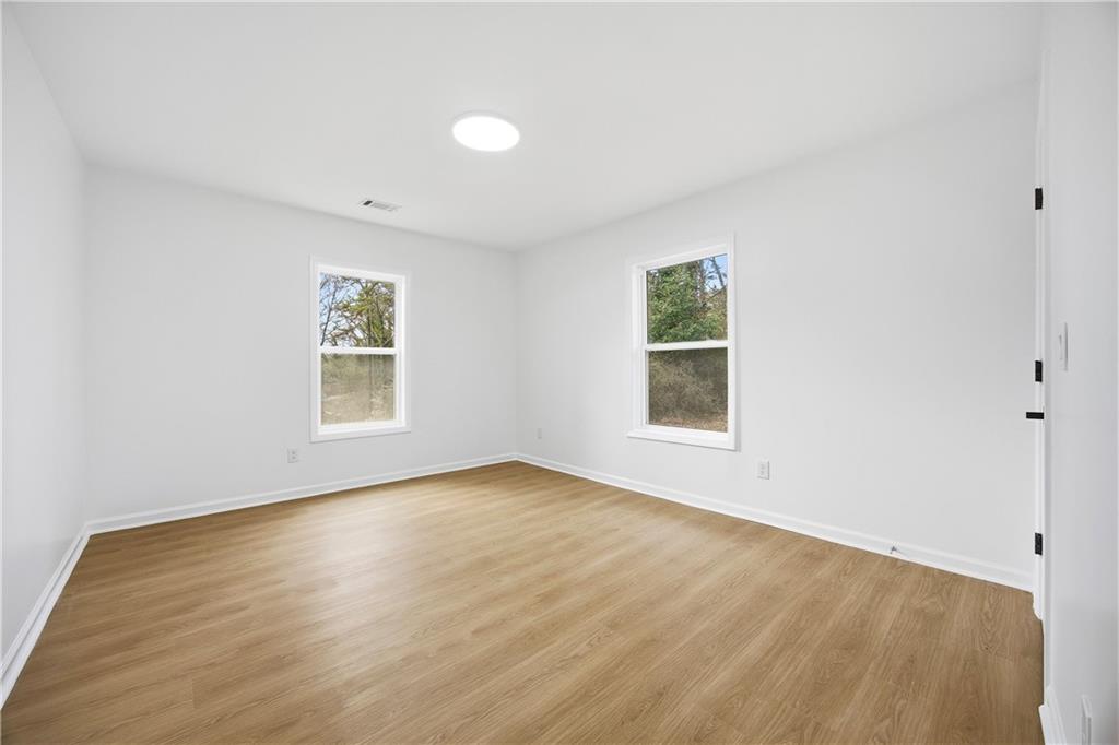 1775 Hadlock Street Southwest Atlanta, GA 30311 - Photo 20 of 27 an empty room with wooden floor and windows