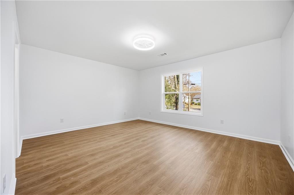 1775 Hadlock Street Southwest Atlanta, GA 30311 - Photo 21 of 27 an empty room with wooden floor and windows